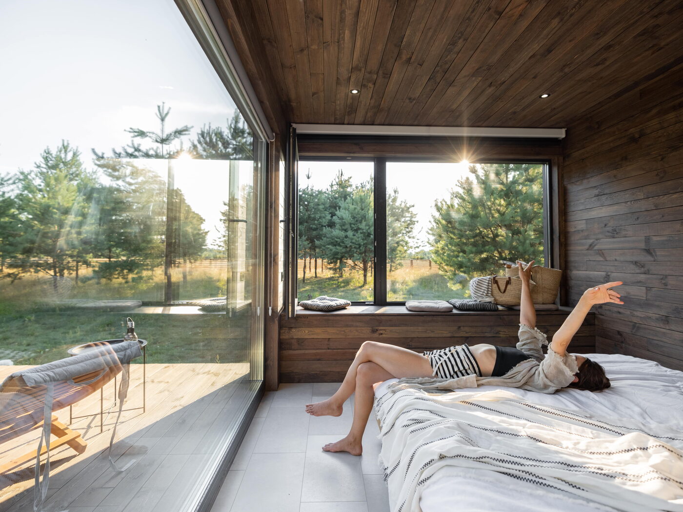 Réveil dans une cabane vitrée ouverte sur la forêt